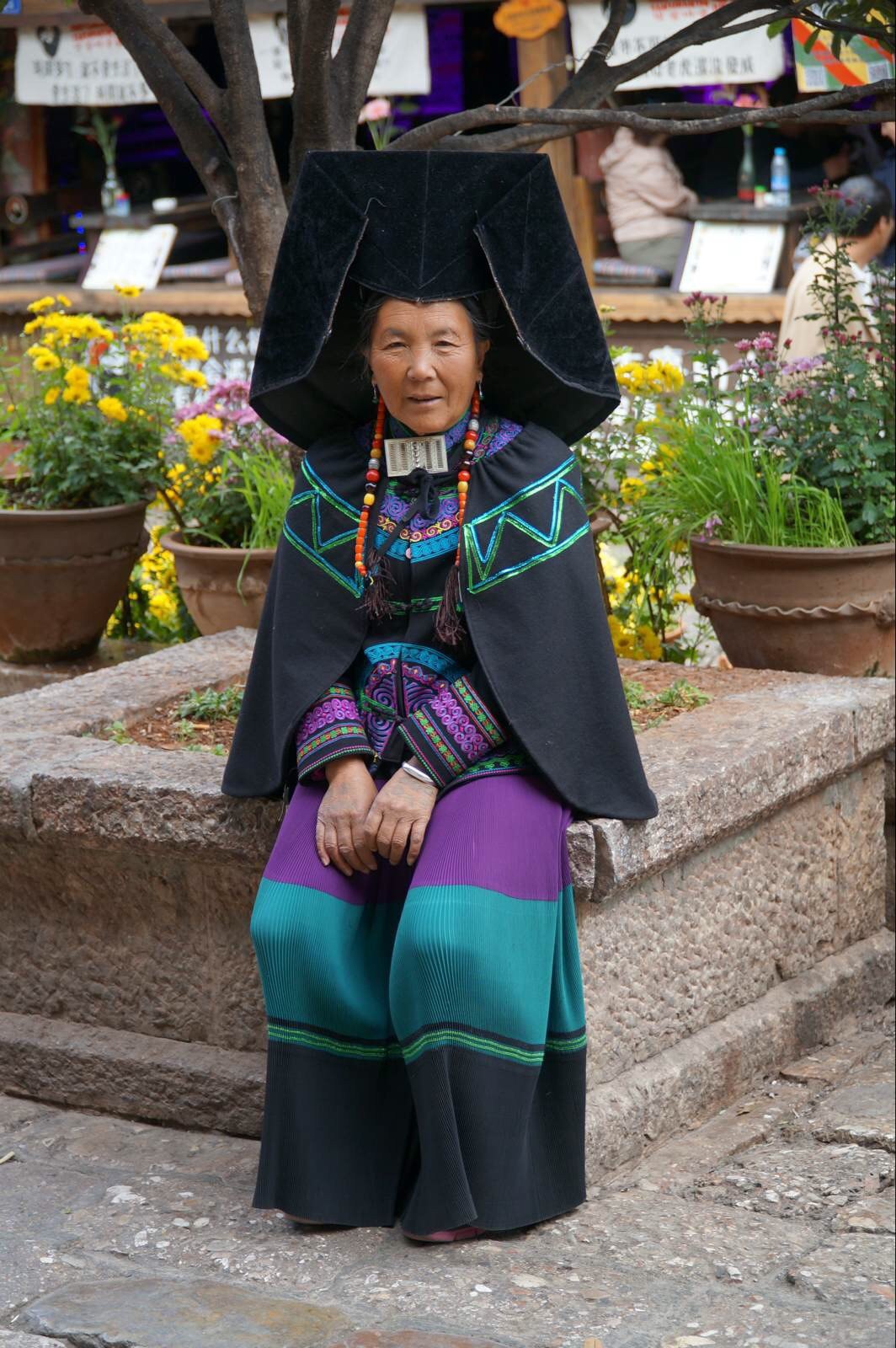 路边和人拍照的彝族老奶奶. 丽江古城