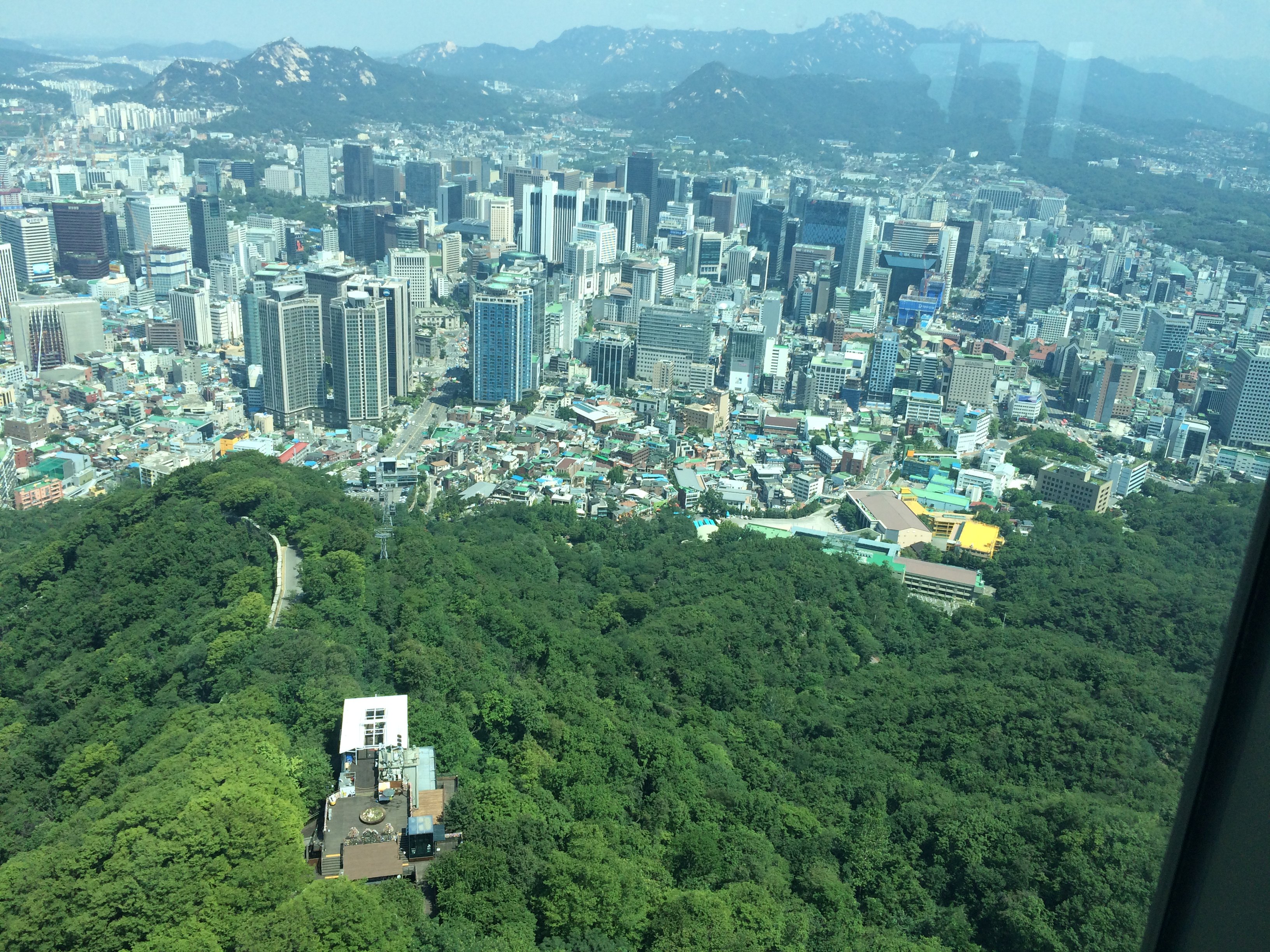 N首尔塔是来韩国必去的景点之一,我们提早在网上订了票,把确认邮件打印出来,拿着打印的纸去一层换门票就可以了,非常方便而且比直接购买要便宜些,弄好票以后就可以根据引导去坐电梯的地方了,之前还会经过一个照相的地方,可以合成和首尔塔的合影,照相之后会给你一张photo number,可以在塔上的观景台换照片,不过一张照片大约60人民币o()o,照相之后就可以去等电梯啦,坐上电梯大约一分钟吧,就到了首尔塔的四层也就是观景的那层。二层和三层有咖啡厅和餐厅,而去五层需要提前预约。