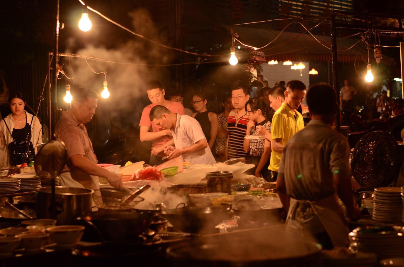 排挡直接摆在路边,食客们先挑好菜品,就在街边的桌子上吃了起来.