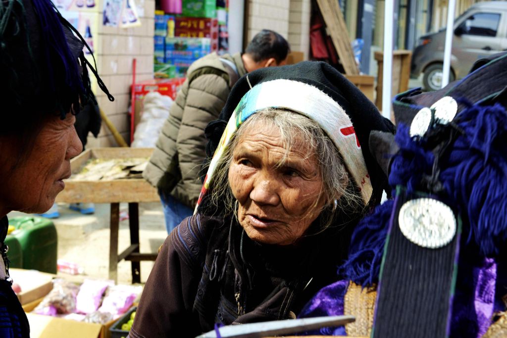 哈尼族老年妇女头上布袋下面是一个大大的背篓.